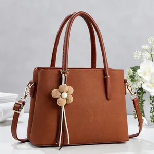 Deep brown lychee textured leather tote bag with beige floral pendant accessory