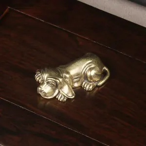 Primer plano detallado de una figura de perro de latón antiguo en madera oscura