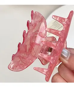 Dettaglio della clip per capelli a farfalla in acrilico marmorizzato rosa con molla