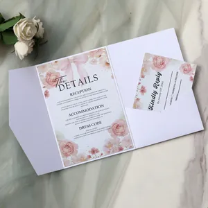 Detail of floral wedding invitation suite with pink roses and elegant ribbon on marble