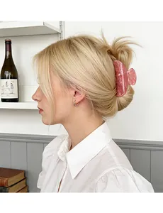 Grande molletta per capelli rosa traslucida con texture glitterata su capelli biondi