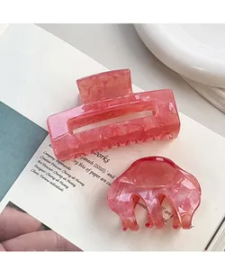 Dettaglio delle pinze per capelli in acrilico rosa con glitter e trama marmorizzata