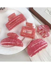 Dettaglio di fermagli per capelli in acetato marmorizzato rosa su piatto di ceramica