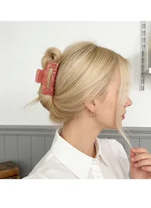 Dettaglio della molletta per capelli in acrilico rosso melograno su capelli biondi