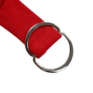 Detail of red sleeveless jumpsuit fabric texture with silver metal D-ring belt buckle