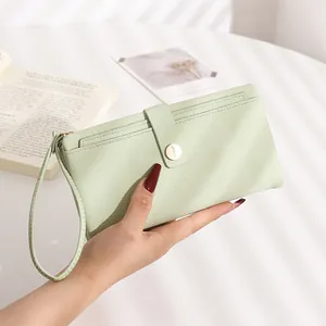 Detail of mint green long wallet showing lychee texture, card slots and wrist strap