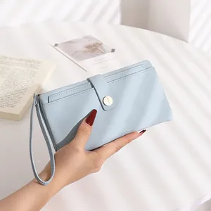 Close-up of light blue long wallet with lychee texture and round metal buckle