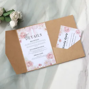 Detail of kraft paper wedding invitation set with pink floral designs and ribbons