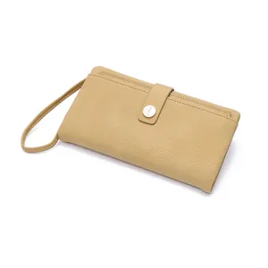 Detail of beige litchi grain long wallet with wrist strap and metal buckle closure