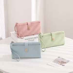 Three elegant long wallets in pink, light green and blue with pebbled leather texture