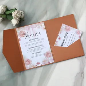 Macro view of terracotta pocketfold wedding invitation with floral details card