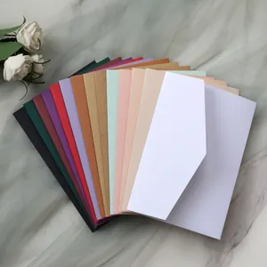 Close-up of elegant kraft paper invitations set in various colors with a marble backdrop