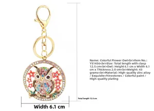 Gros plan d'un porte-clés chouette doré avec strass colorés et breloque florale
