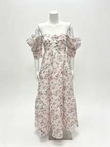 Détail d'une robe fleurie rose à volants avec encolure bardot et manches bouffantes