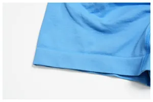 Macro detail of high-waist yoga shorts showing the blue seamless fabric and ribbed hem
