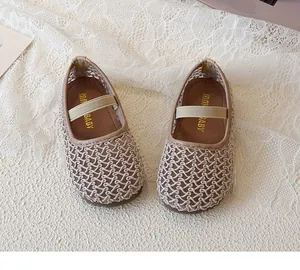 Close-up of girls' woven mesh Mary Jane flats in beige with elastic strap and brand logo