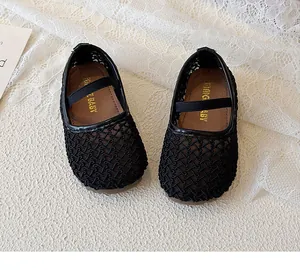 Top view of black breathable mesh baby shoes with elastic straps on white lace