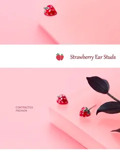 Detailed close-up of cute red strawberry earrings with green leaves and silver pins