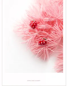 Close-up of S925 silver red strawberry stud earrings with green leaf enamel detail