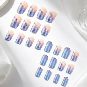 Dettaglio di unghie finte quadrate corte con sfumatura rosa-blu e glitter viola
