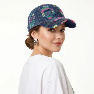 Close-up of distressed denim baseball cap featuring colorful embroidery and ripped details