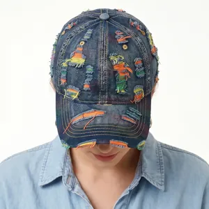 Distressed denim baseball cap with colorful stitching and ripped details on a model