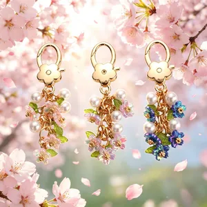 Colorful floral pearl keychains in pink, purple, and blue with gold flower clasps