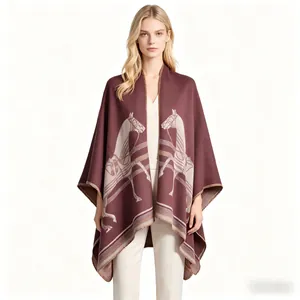 Detailed close-up of burgundy equestrian poncho featuring white horse pattern and knit texture