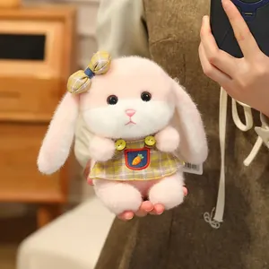 Detail of plush bunny keychain in pink dress with carrot embroidery and yellow bow