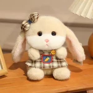 Lop-eared rabbit plush toy in beige with plaid dress and carrot embroidery on wooden desk