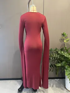 Détail de robe sirène rouge élégante avec des manches cape longues jusqu'au sol