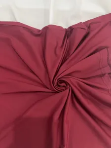 Vue détaillée du tissu côtelé bordeaux avec un effet de drapé en spirale élégant