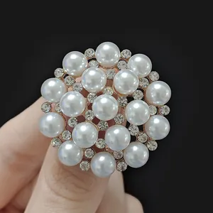 Macro shot of elegant gold alloy brooch with cluster of pearls and sparkling rhinestones