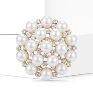 Macro shot of circular snowflake brooch with white pearls and sparkling rhinestones