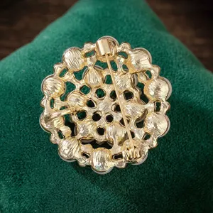 Golden snowflake brooch with pearls and rhinestones shown from a detailed back view