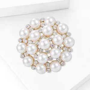 Macro detail of snowflake pearl brooch with gold tone metal and clear rhinestones