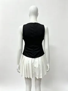 Detail view of the elegant invisible zipper and pleats on the back of this black and white dress