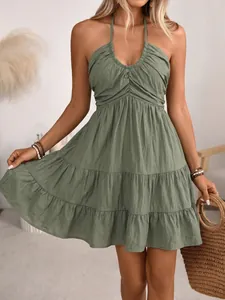 Close-up of olive green halter neck dress featuring smocked bodice and tiered layers