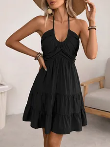 Detail of black halter dress featuring tiered ruffle skirt and smocked bodice texture