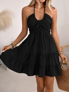 Detail of smocked halter neckline and tiered cake skirt on this black summer midi dress