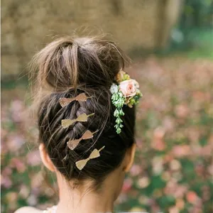 Detailed view of metal bow hair clips on an elegant hairstyle with floral accents