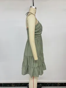 Detail view of the tiered ruffle hem and pleats on this olive green halter dress