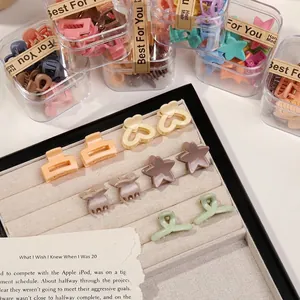 Macro shot of assorted matte Morandi mini hair clips in a transparent gift box packaging