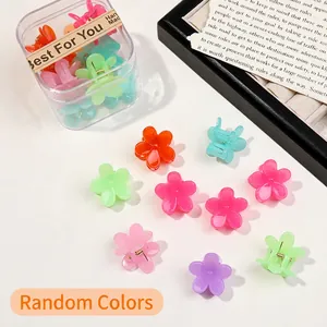 Macro view of colorful mini flower hair claws in a transparent plastic storage box