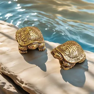 Close-up of solid brass turtle figurines with antique finish on a rock by the water