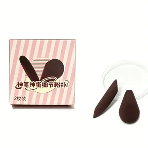 Detail view of two dark brown detail makeup puffs for eyes and nose contours