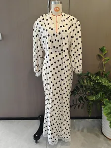 Detail of the white polka dot dress showing delicate lace trim on the sleeve and hem