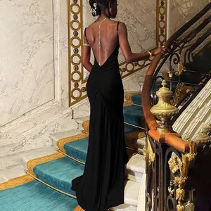 Macro view of backless detail with golden chains on this black evening dress