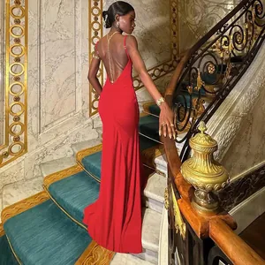 Detail of red backless evening gown featuring a deep V-cut and delicate gold chain