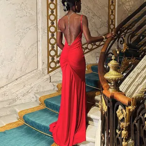 Detail of red backless evening dress with fine chain jewelry and draped fabric